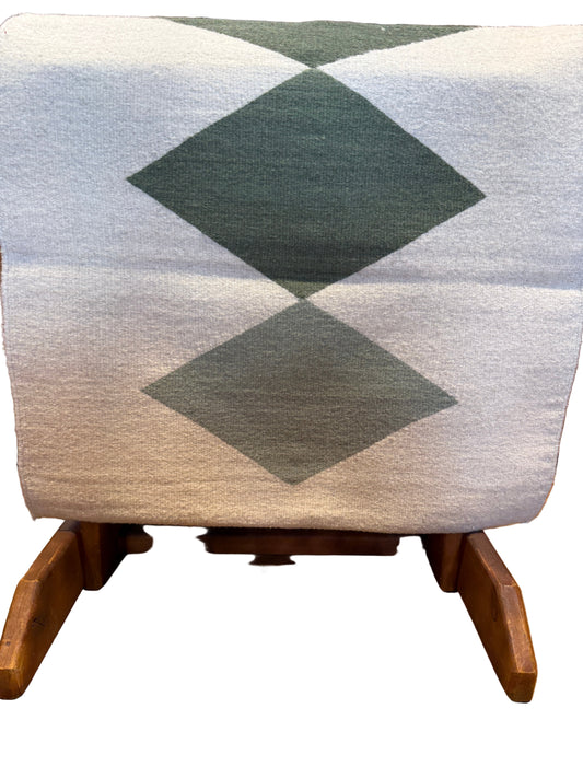 Textile with geometric pattern draped over a wooden surface