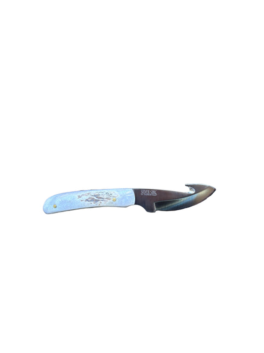Knife with a white handle on a textured black surface next to wooden planks
