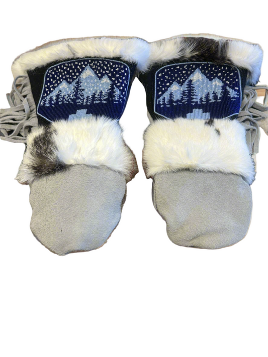Pair of baby booties with fur trim and embroidered design on a white background