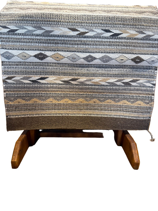 Textile with a diamond pattern draped over a wooden surface