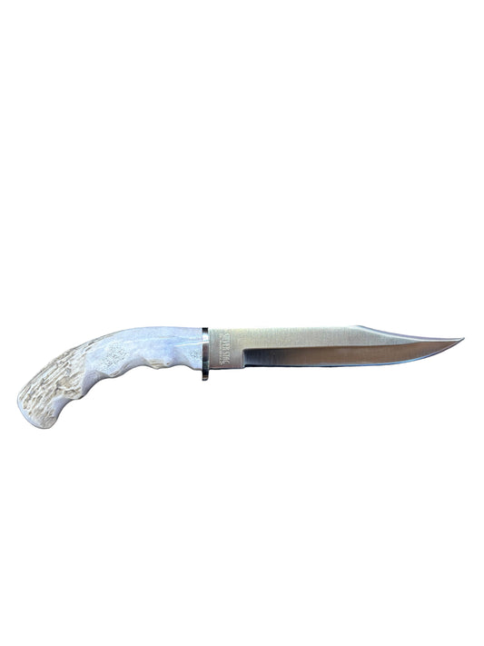 Knife with antler handle on a dark cloth against a wooden background