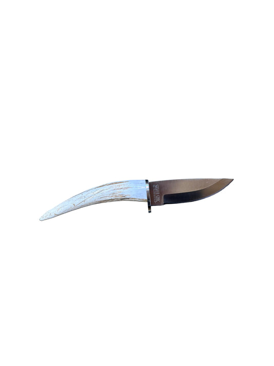 Knife with a white handle on a textured surface between wooden panels