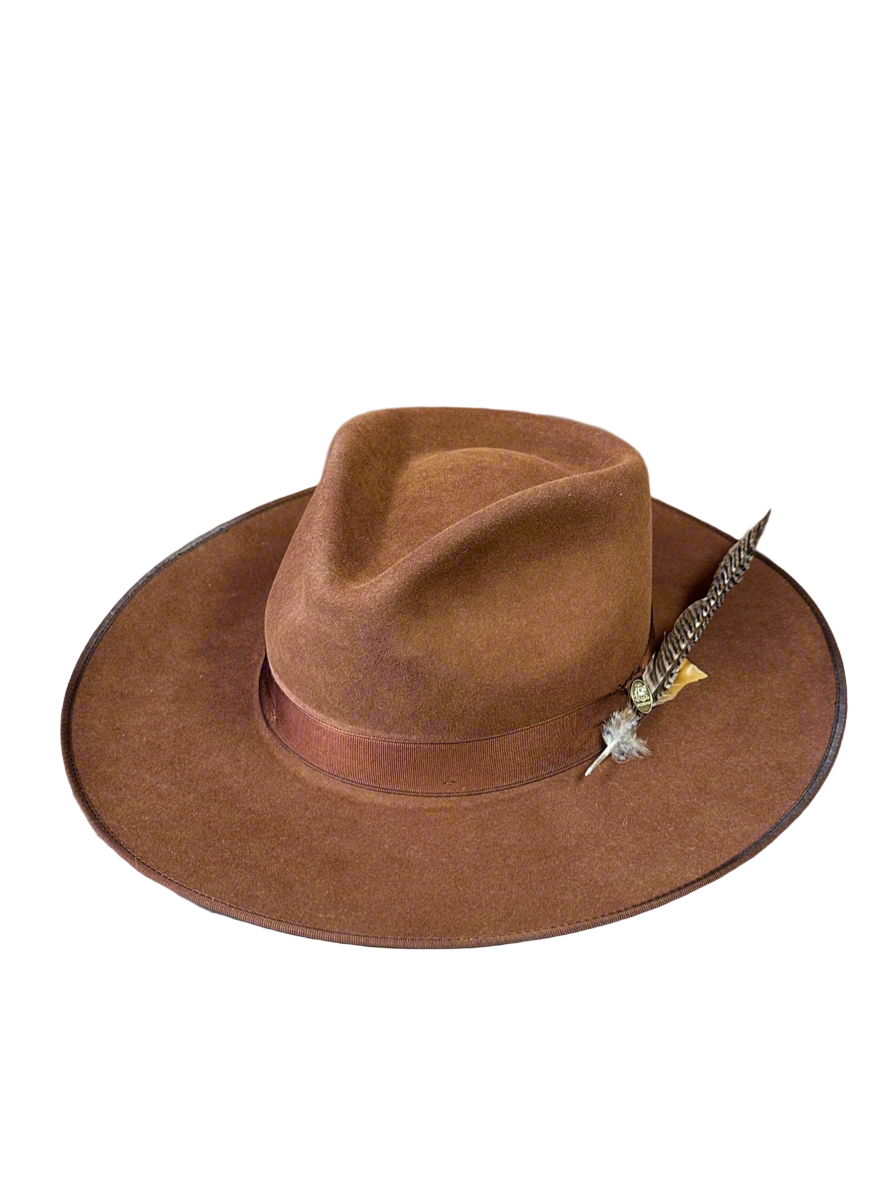 Brown cowboy hat with a feather and star accessory on a white background