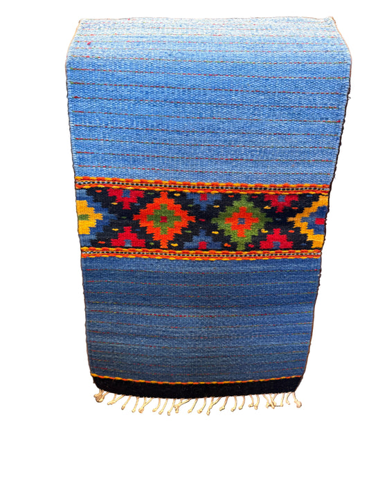 Blue woven mat with colorful patterns on a wooden staircase