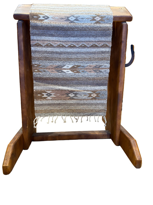 Wooden step stool with a patterned rug on a wooden floor