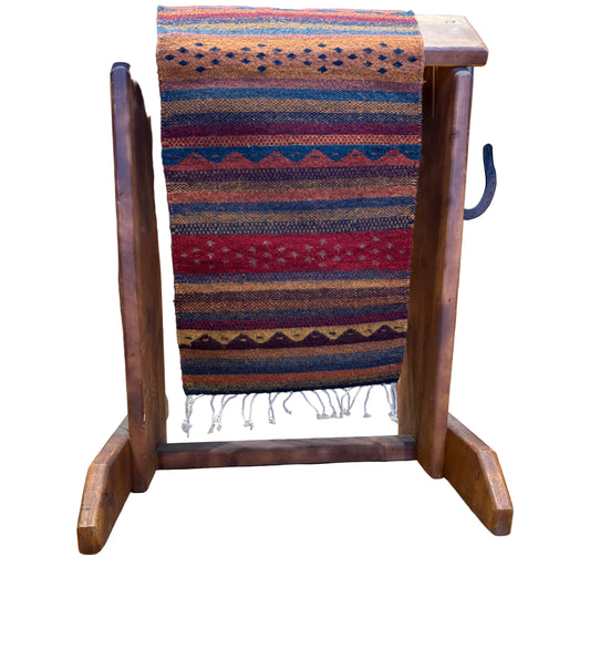 Wooden stand with a striped fabric draped over it on a wooden floor.