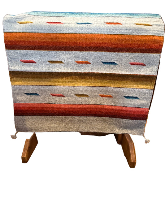 Colorful striped rug draped over a wooden chair