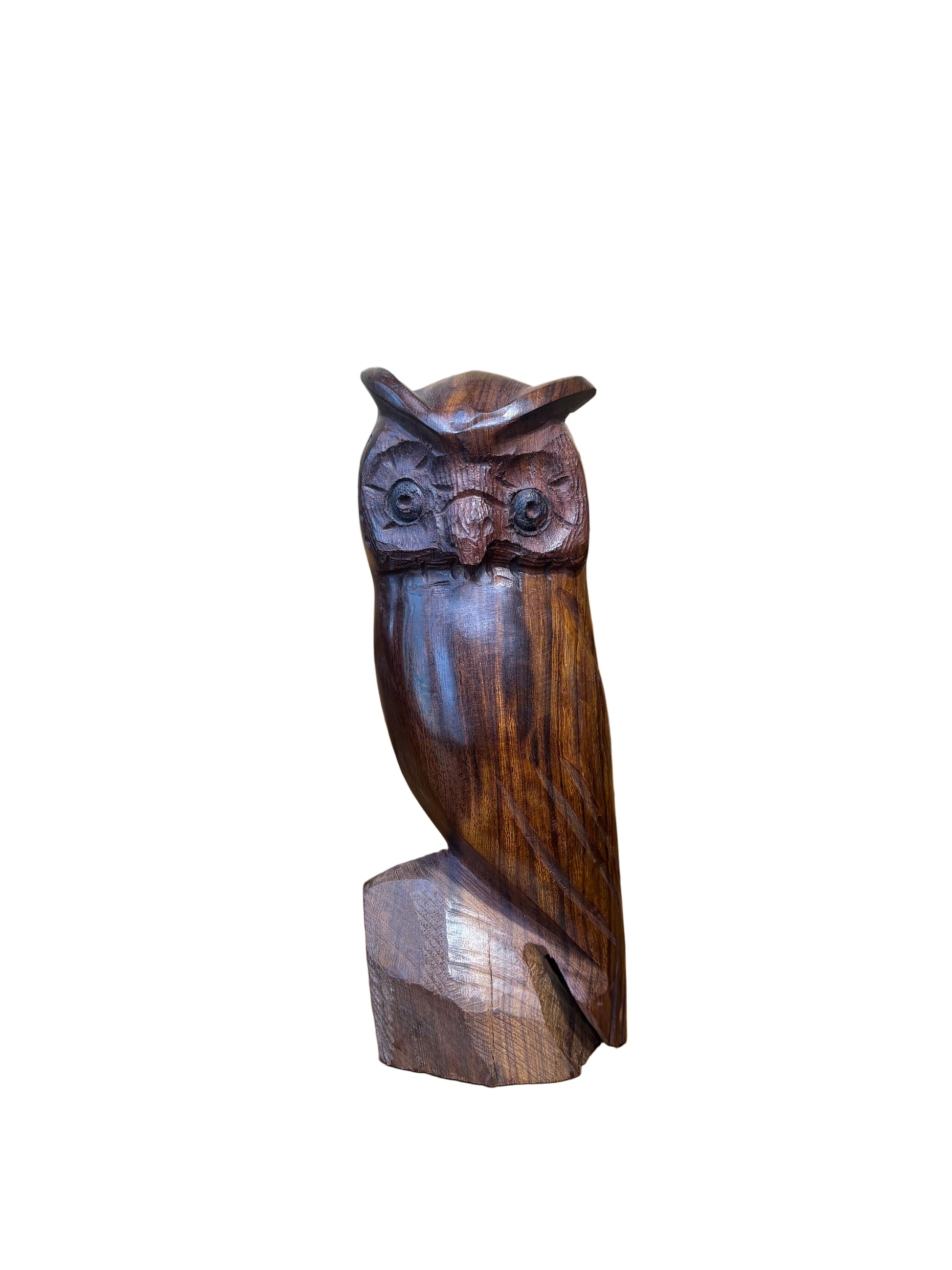 Wooden owl sculpture on a wooden surface with a rustic background
