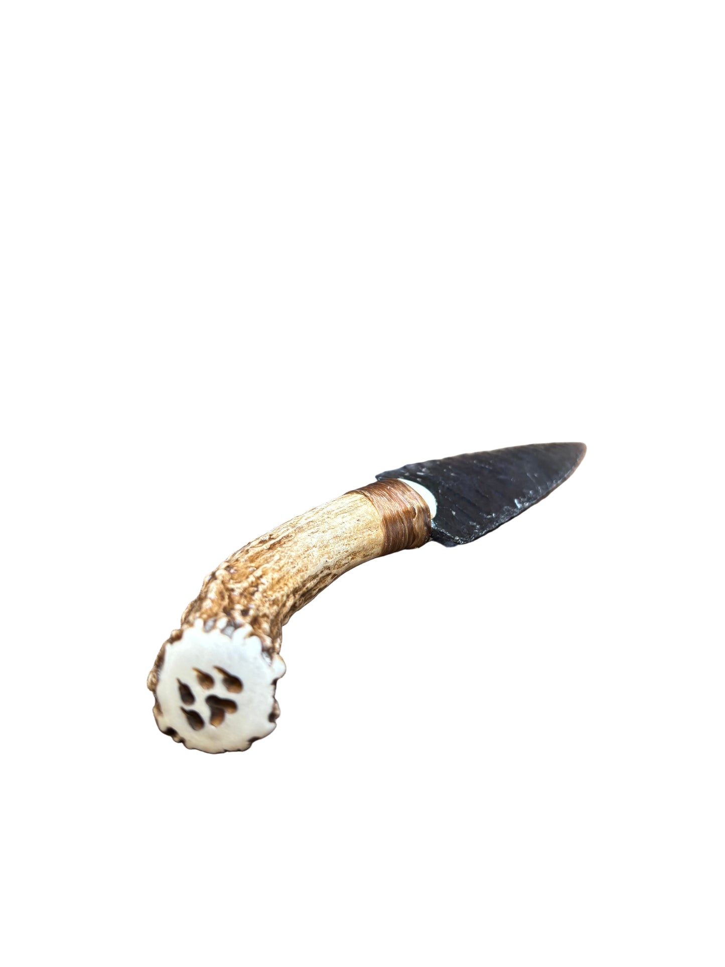 Decorative pillow with a knife and deer antler on a patterned fabric background