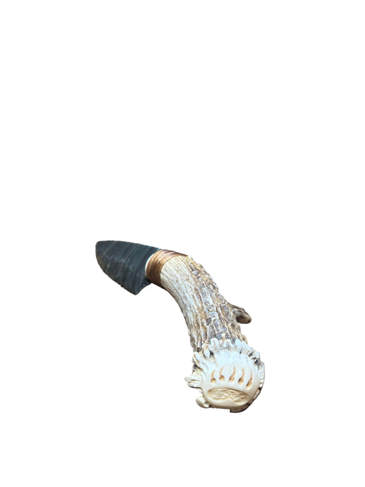 Decorative antler on a patterned fabric with wooden background