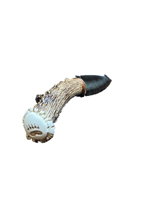 Decorative antler with white tip on a patterned fabric background