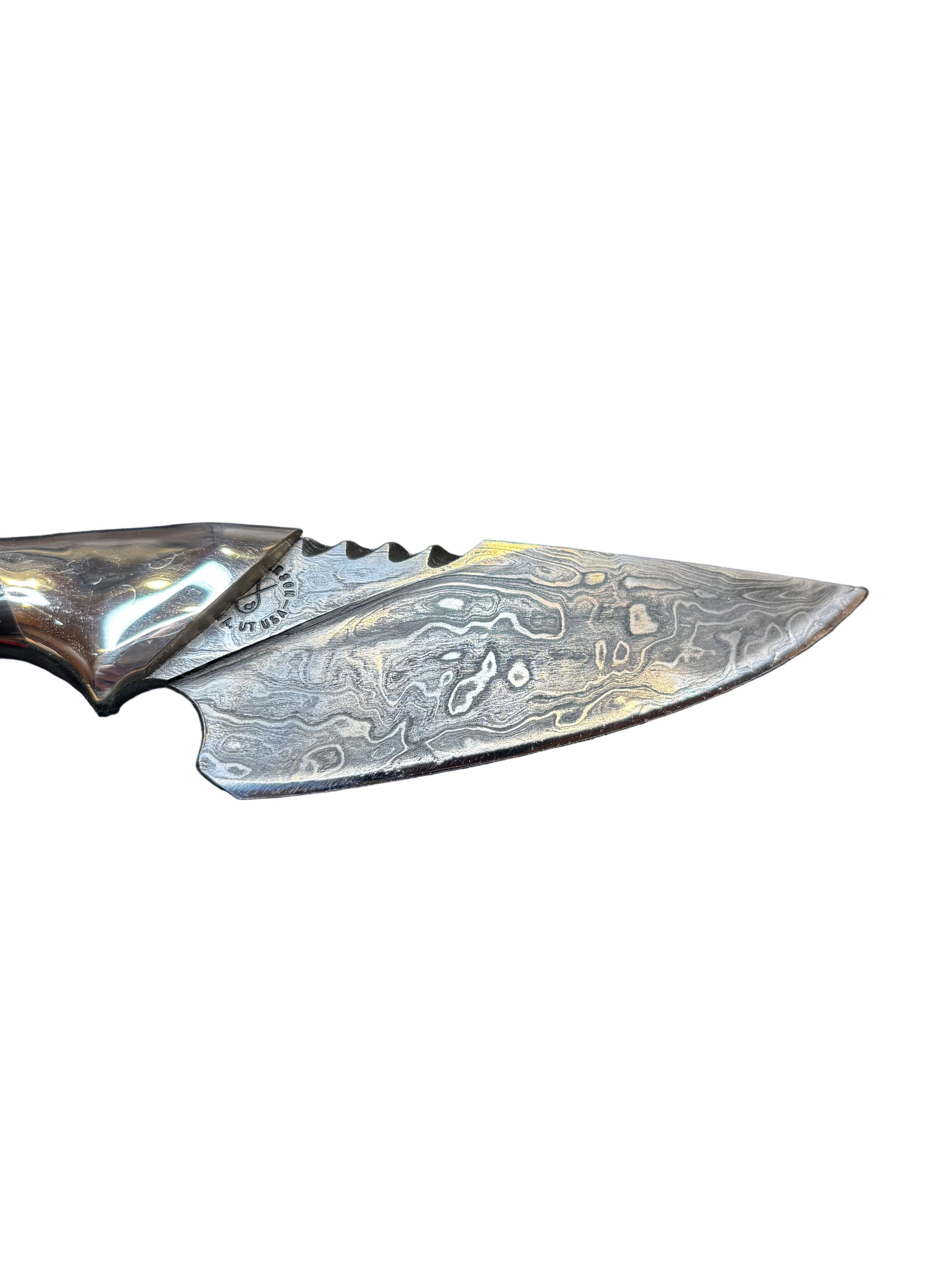 Close-up of a knife blade with a detailed pattern on a white background