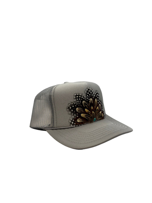 Gray visor with decorative feathers on a white background