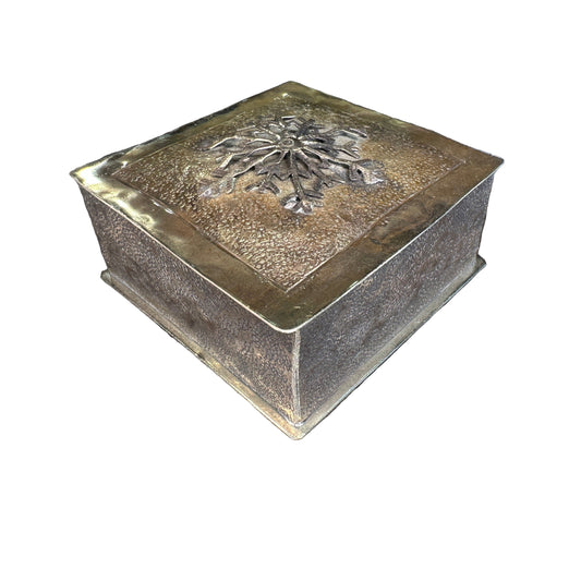 Bronze box with embossed design on a patterned rug