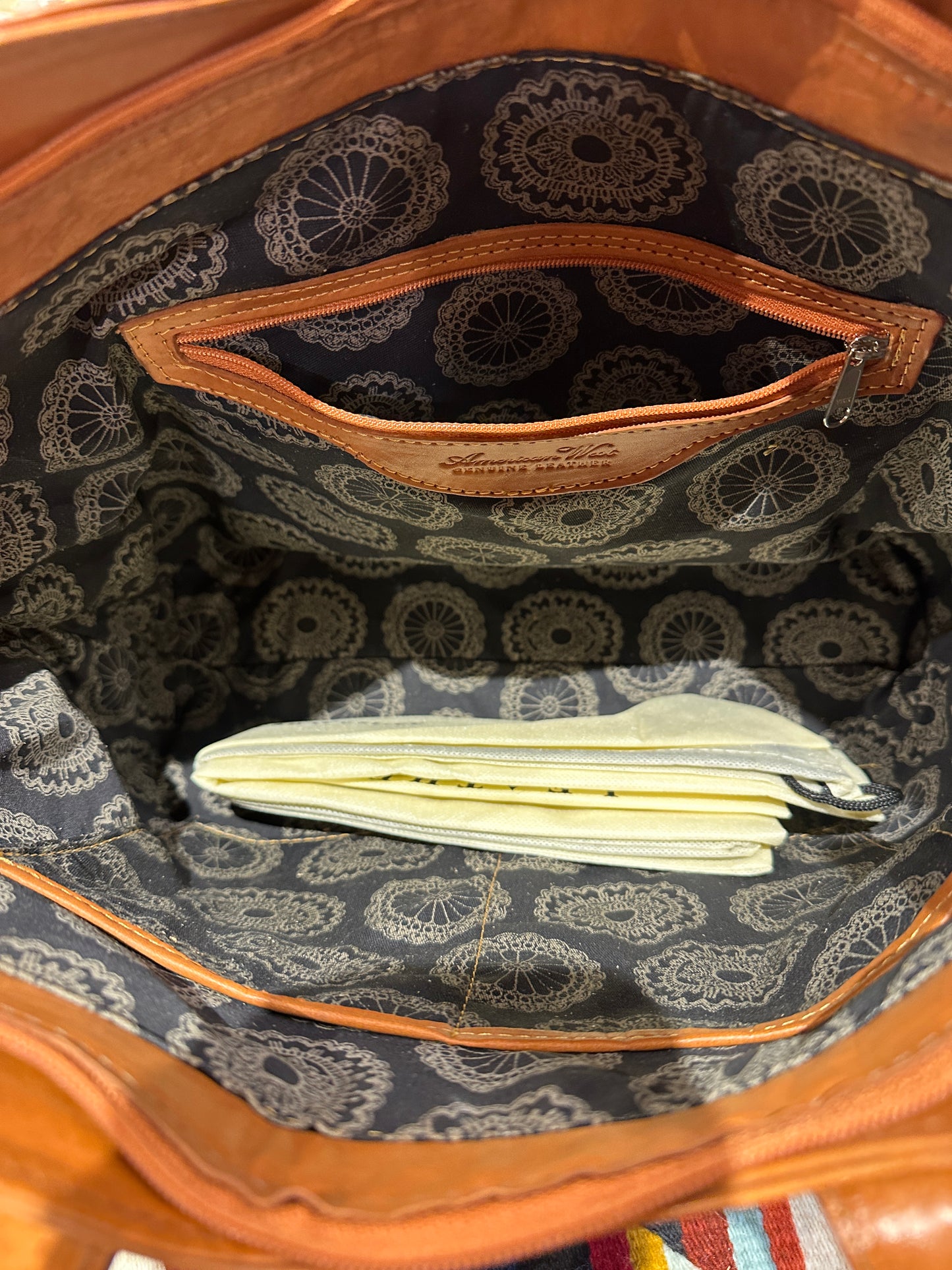 Brown leather tote bag with decorative handles on a white background
