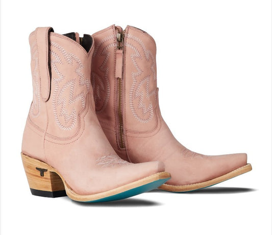 Pair of pink cowboy boots with wooden heel on a white background